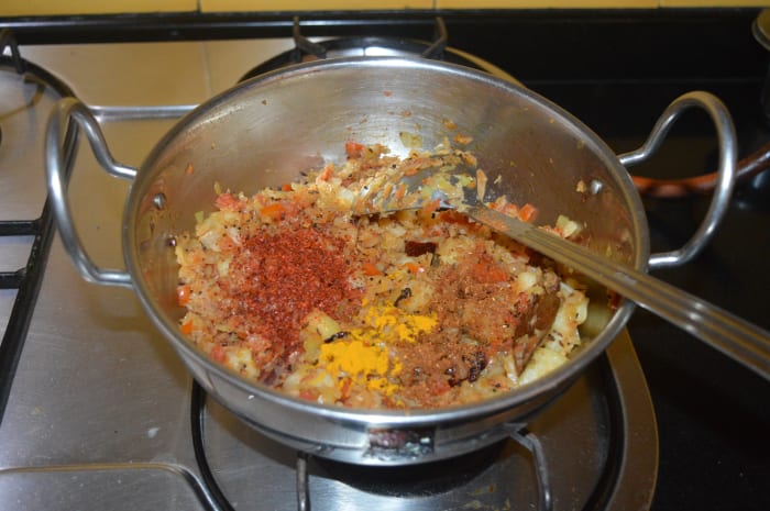 Step three: Lower the heat. Add red chili powder, garam masala powder, coriander powder, and turmeric powder.