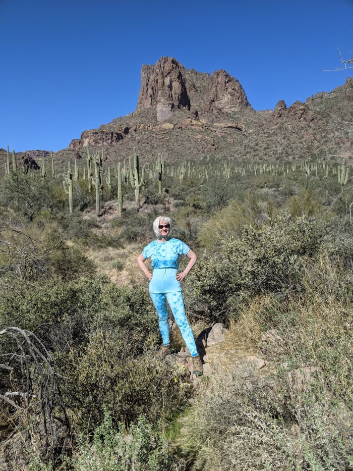 My wife at start of Carney Springs Trail Head. Wave cave is the brownish rock at the bottom right of the distant mountain.