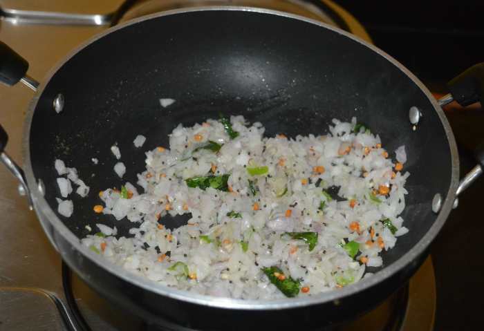 Step three: Add chopped onions, chopped green chilies, and some salt. Increase the heat. Saute until the onions become transparent.