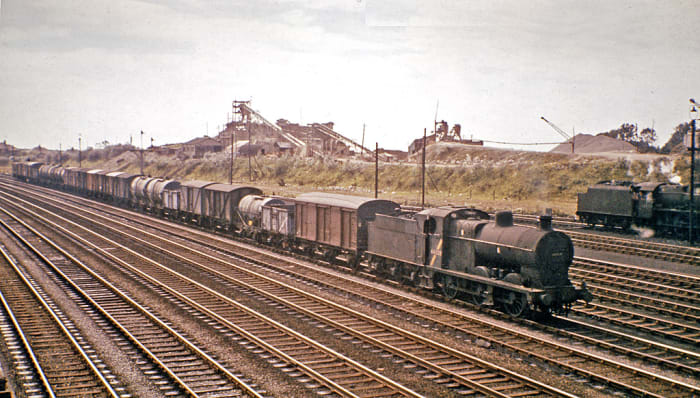 Goods... often overlooked, under-represented on layouts with expresses whizzing past The humble 0-6-0 and its workload. An ex-Midland Railway 0-6-0 mixed freight locomotive clanks past an industrial north-western backdrop with a lengthy trip-working