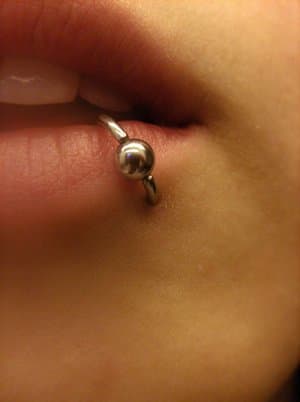 A lower lip piercing does not actually pierce the lip itself, but rather the skin below and inside the lip.