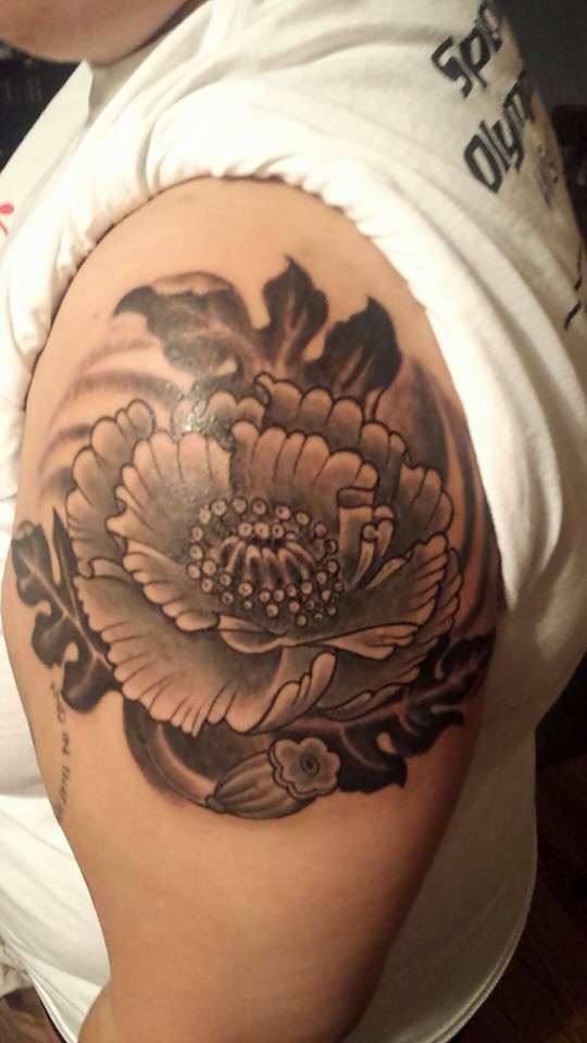 You can expect exquisite detail in a flower of this size. This tattoo was done in black and grey style.