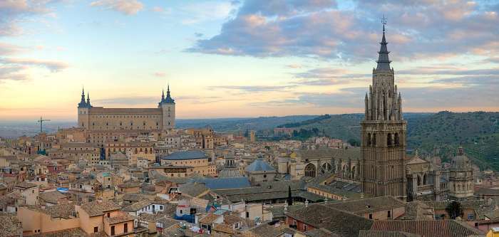 Panorama of the Toledo Skyline in Spain at sunrise. On the left is the Alcázar of Toledo and on the right is the Cathedral of Toledo.