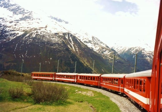 View of the back end of the Glacier Express Train from my window view closer to the front of the train in Switzerland near Tasch.