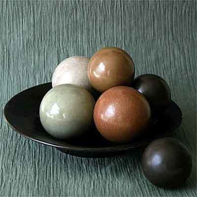 The color of the finished dirt balls comes from the color of the dust or clay used to coat the outside layers of the tightly-compressed ball of mud.