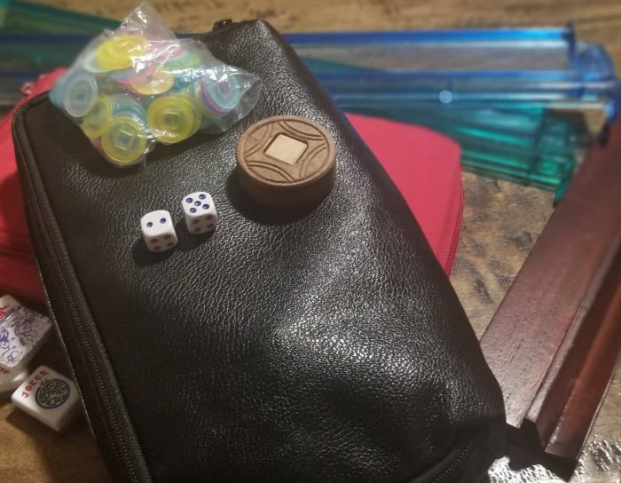 Here are tile storage pouches, dice, a betting disk, scoring coins, racks, pushers, and Mah Jongg tiles.
