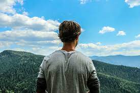 A man stands and looks over the world. Travel is important and can help you see the world and it's meaning.