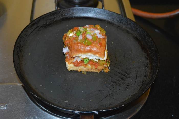 Gently press it with a spatula so that both halves stick together. Turn off heat. Transfer the masala pav to a serving plate.