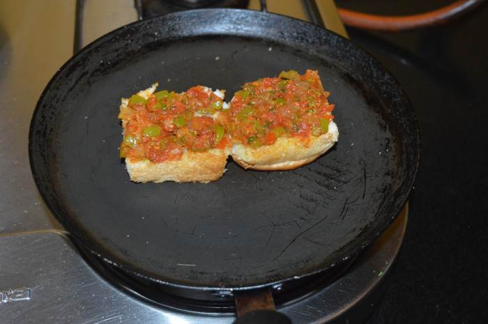 Step five: Start making masala pav. Heat a pan and add butter. Cut a pav bun horizontally in the middle and place it on the pan. Toast it lightly on both sides.
