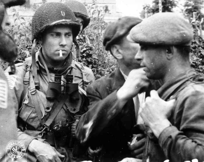 A member of the American 82nd Airborne division meets with members of the French resistance on D-Day.