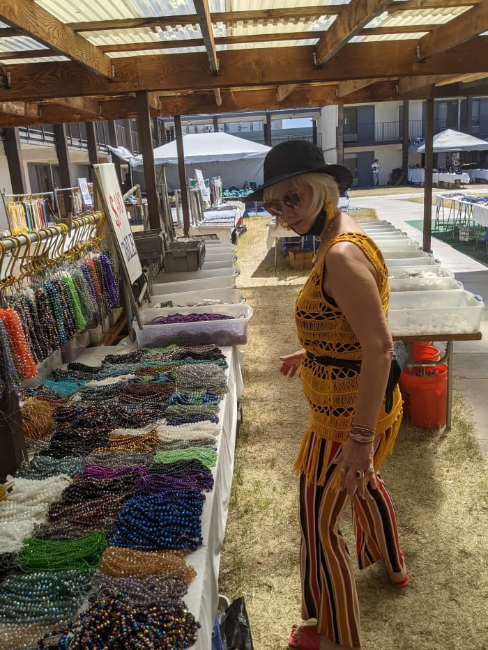 My wife looking through piles of beads seeking ones to make necklaces with