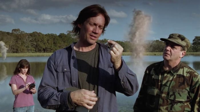 Dr. Karen Watkins (Maeghan Albach) and Jake Denning (Kevin Sorbo) test for something, while Col. Fielding (Tom Luce) waits for the results