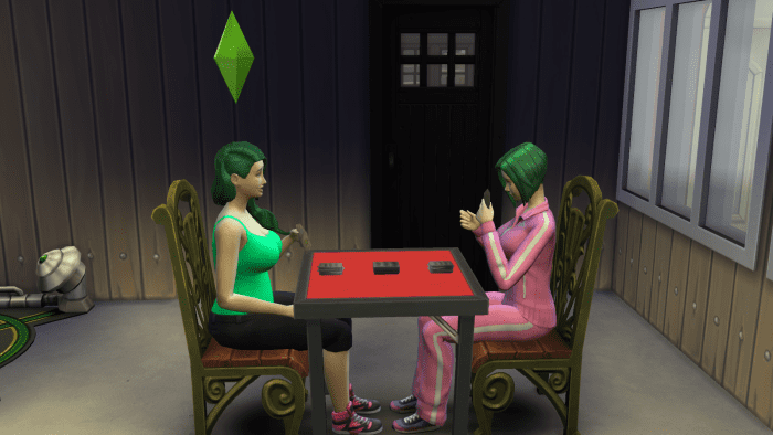 Two Sims playing cards in "The Sims 4". Playing games can build a Sim's Logic skill.