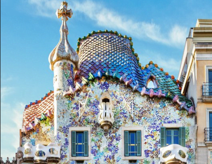 The rooftop of La Casa Battló. Notice the curves of the rooftop and the colorful, scale-like mosaic shapes that resemble dragon scales. Many say that Gaudi wanted to evoke the image of a dragon with this design.
