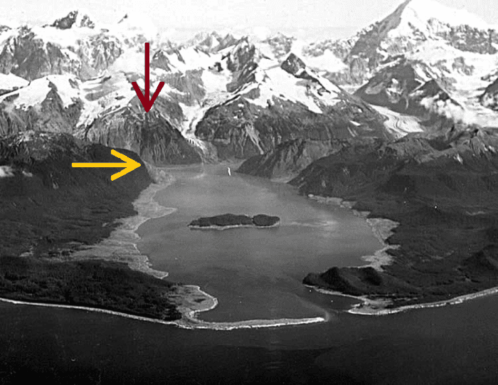 This photo was just taken a few weeks after the Lituya Bay megatsunami struck. The red arrow demonstrates the starting point of the landslide and the yellow arrow indicates the height on land where the vegetation was stripped.