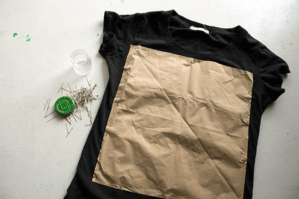 Pin the paper pattern to the shirt, making sure to go through both layers.