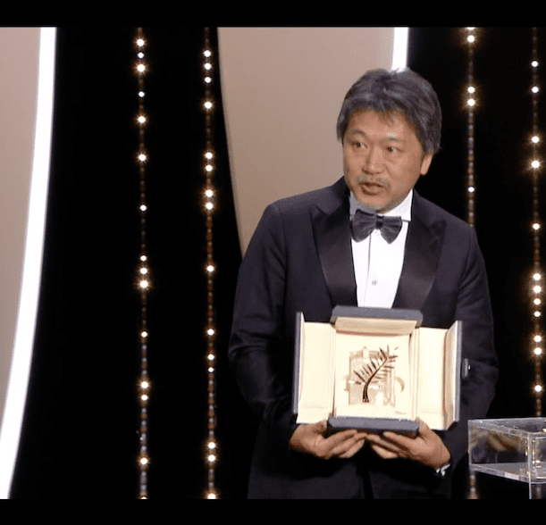 Director Hirokazu Kore-eda, seen here with his Palme D'Or award for the film, creates a heartwarming portrait of an unconventional family struggling to survive as well as stay together.