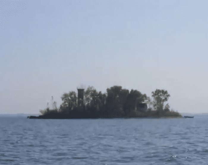 TURTLE ISLAND - Only 1.5 acres in Lake Erie on the northern border of Ohio. Divided in half in the War of Toledo, no construction can be done on the island and several building projects lie in abandonment. See the old light house on the left.