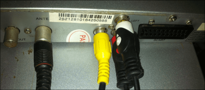 The RCA cables for video (yellow) and audio (red and white), connecting at the back of the decoder. The black plug on the left is the antenna cable.