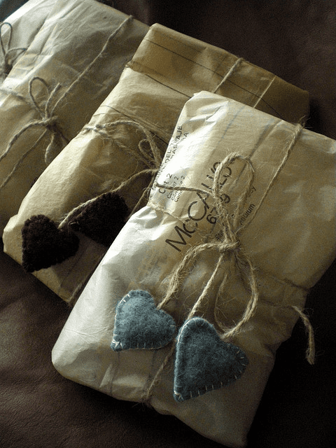 Clever idea for using sewing pattern tissue paper, which adds interest has has a vintage, rustic feel to it. I also love the fact that the colour of the wool hearts on the outside mirrors what is inside the parcel - and they're generous freebies too!