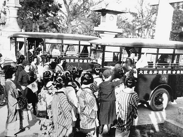 Public transport developed quickly in Japan. This bus in 1929 was already much more sophisticated. Long lines of people are waiting for the bus.