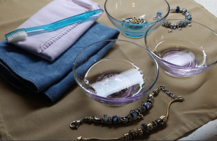 how to clean Pandora style charms and bracelets - photo of three bowls, soft cloth, polishing cloth and toothbrush