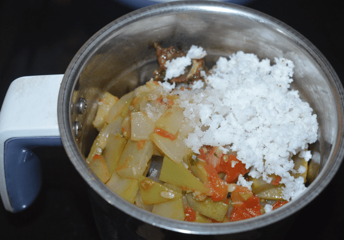 Step four: Transfer the mixture to a mixer jar. Add grated coconut, tamarind pulp, and remaining salt.