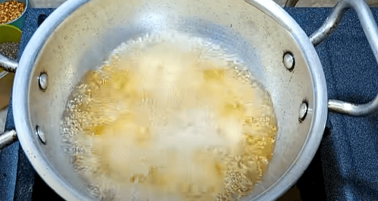 Using a tablespoon, take small portions of the mixture and drop them one by one into the hot oil to fry. Do not crowd the pan as the chicken needs enough space to properly cook.