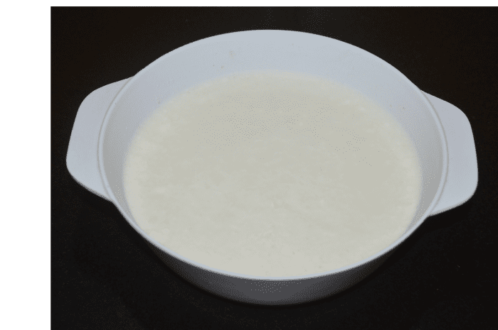 While adding water little by little, prepare a dropping consistency (idli batter consistency) batter. Cover it and rest for 8 hours or overnight.