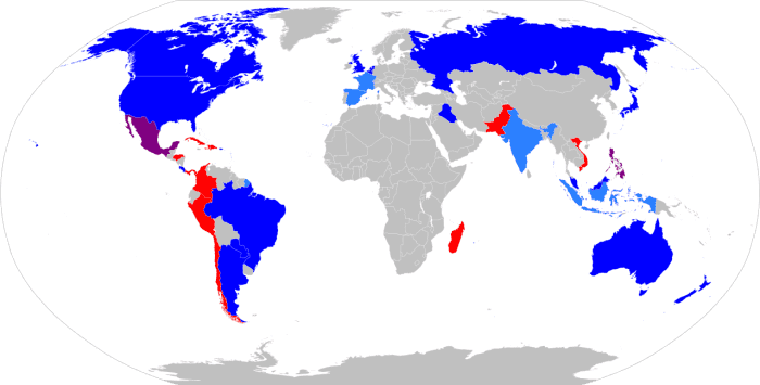 Red marks countries where cockfighting is legal and dark blue where it is not. Light blue and magenta indicate some bans. Grey means complex rules apply.