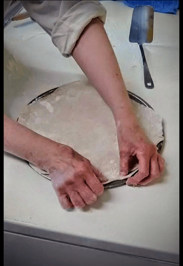 Fit the dough onto the greased pan. Prick with a fork if you wish to prevent air bubbles. Bake 5-7 minutes in a 400* F. oven. This is not the total baking time, but will seal the crusts a bit against invading tomato sauce later.
