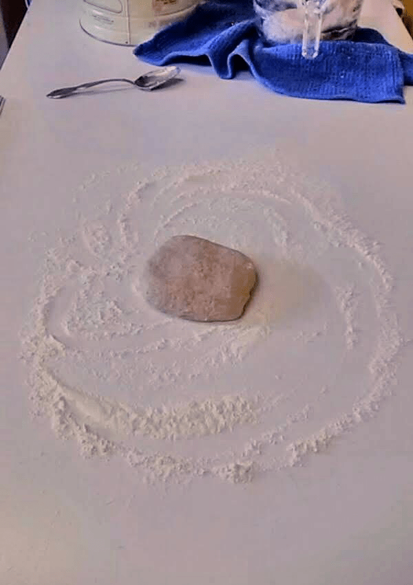 The dough ball has rested about five minutes, and is ready to roll. You may not need this much flour. Push extra flour off to the side, keeping your working surface only sparsely covered.