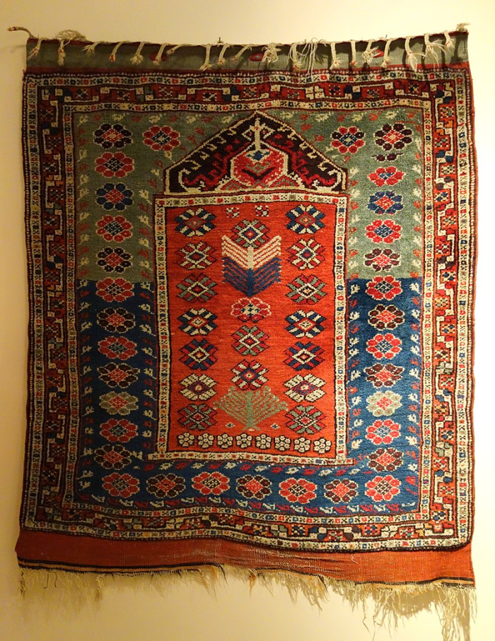 The niche at the top of the rug represents the mihrab and the direction of prayer.
