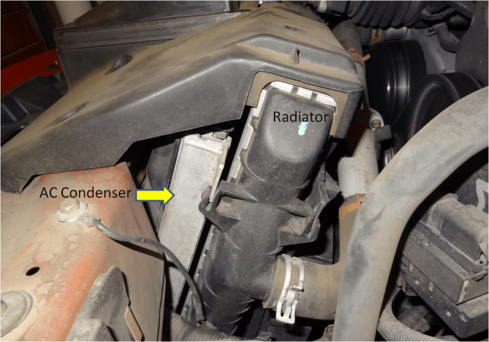The AC condenser sits in front of the radiator. Depending on the model, the grill and radiator may have to be removed.