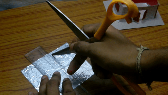 Now to make the wavy designs like that of a tin roof you need to make parallel markings on the shiny surface of the roof. For this you can use a key or the blunt edge of the scissor. Take care not to damage the roof while marking.