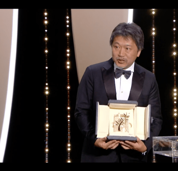Director Hirokazu Kore-eda, seen here with his Palme D'Or award for the film, creates a heartwarming portrait of an unconventional family struggling to survive as well as stay together.