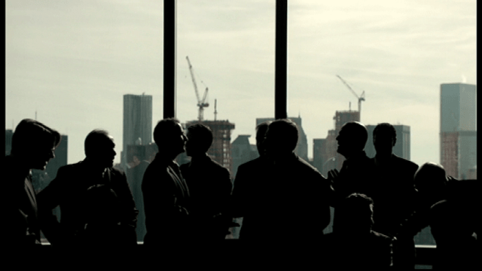 The rich elite, conversing in a conference room and the opening shot of the pilot episode. Image copyright of USA Network.