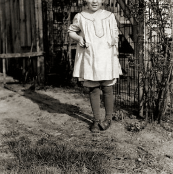 The oldest child, a girl, looked out of the window and saw someone looking at the house. It was a little white girl, and she was intently watching them as they played in a room that had the window curtains open.