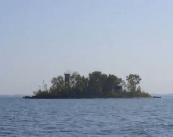 TURTLE ISLAND - Only 1.5 acres in Lake Erie on the northern border of Ohio. Divided in half in the War of Toledo, no construction can be done on the island and several building projects lie in abandonment. See the old light house on the left.