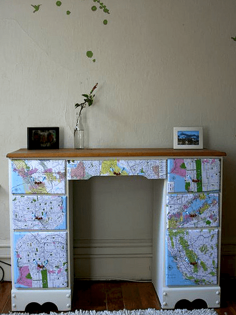 The surface of the wooden desk was cleaned down, a spray glue was used on both the paper and the wood, it was left to dry a bit and then the maps were stuck onto the desk. When the glue was completely dry, a thick Mod Podge coating was applied.