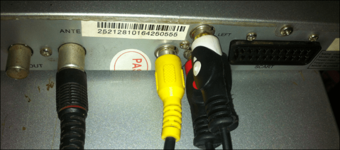 The RCA cables for video (yellow) and audio (red and white), connecting at the back of the decoder. The black plug on the left is the antenna cable.