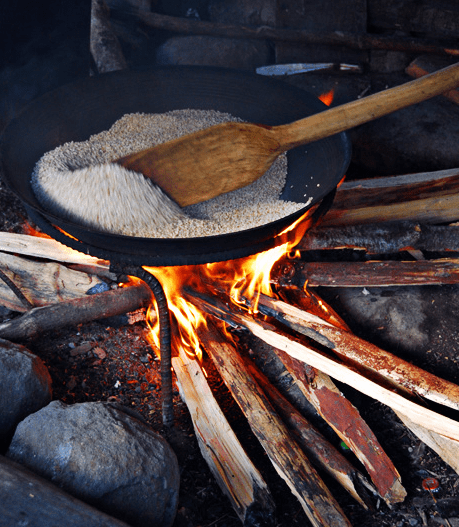 Roasting the rice in a large wok and stir continuously with a wooden paddle to avoid burning (Image Credit: AkosiSuperEdwinK from pinoyphotography.org)