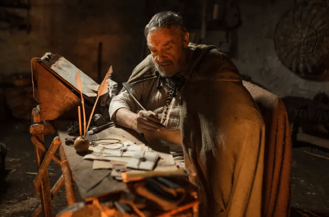 John Rhys-Davies (from Lord of the Rings) as Bishop Patrick writes a letter in the docudrama "I Am Patrick" via Fathom Events