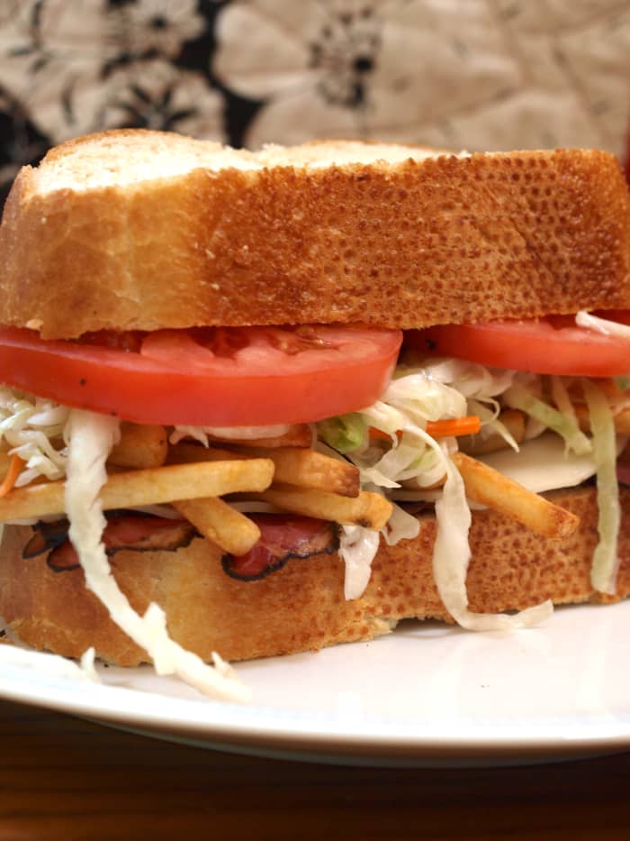 Pittsburgh-style sandwich with meat, fries, and coleslaw on Italian bread.