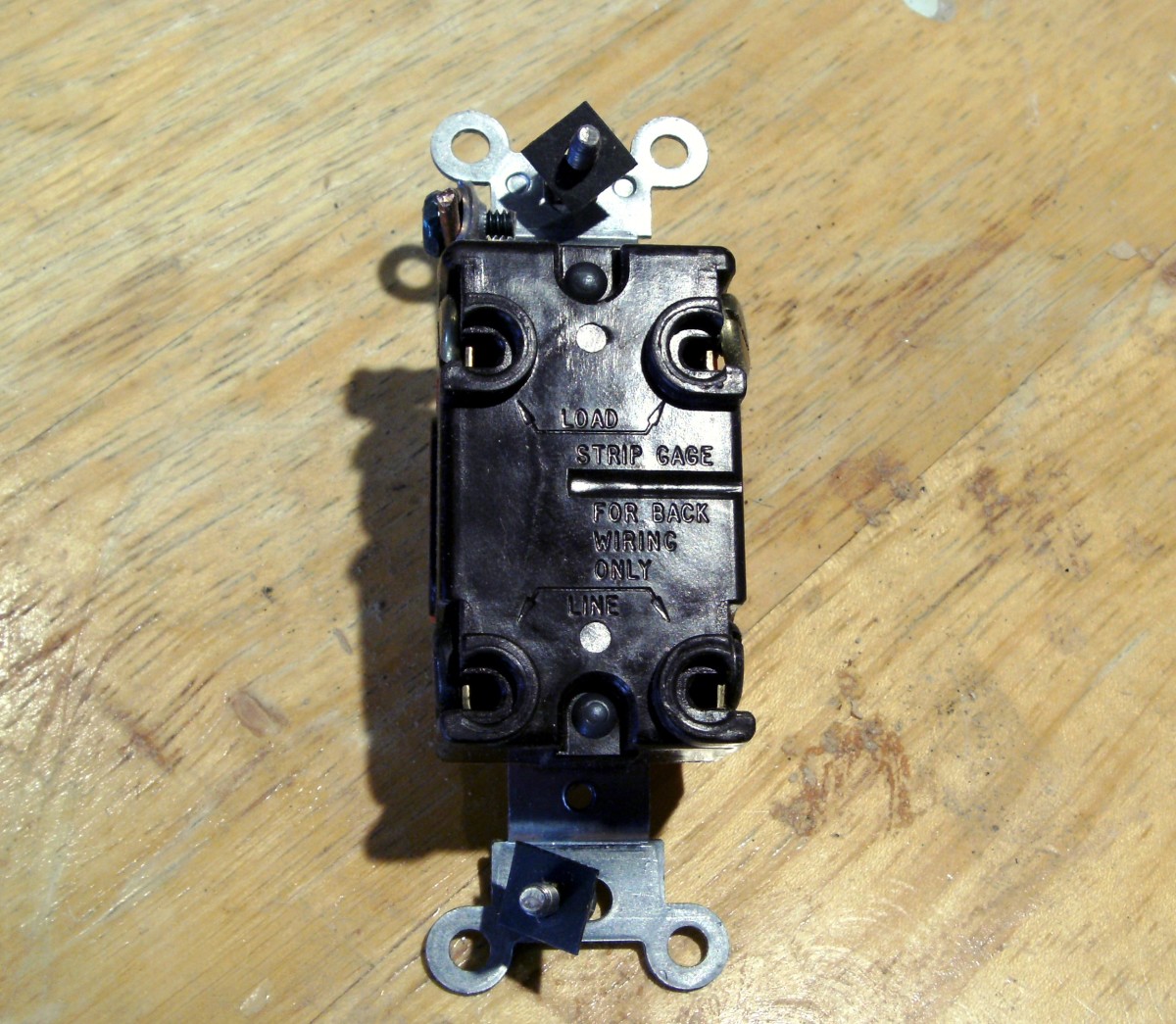 This is the back side of a 4-way switch. There are four places to terminate wire, plus a green screw at the top of the switch for the green or bare ground wire. This switch has screws at the sides as well as the holes in the back.