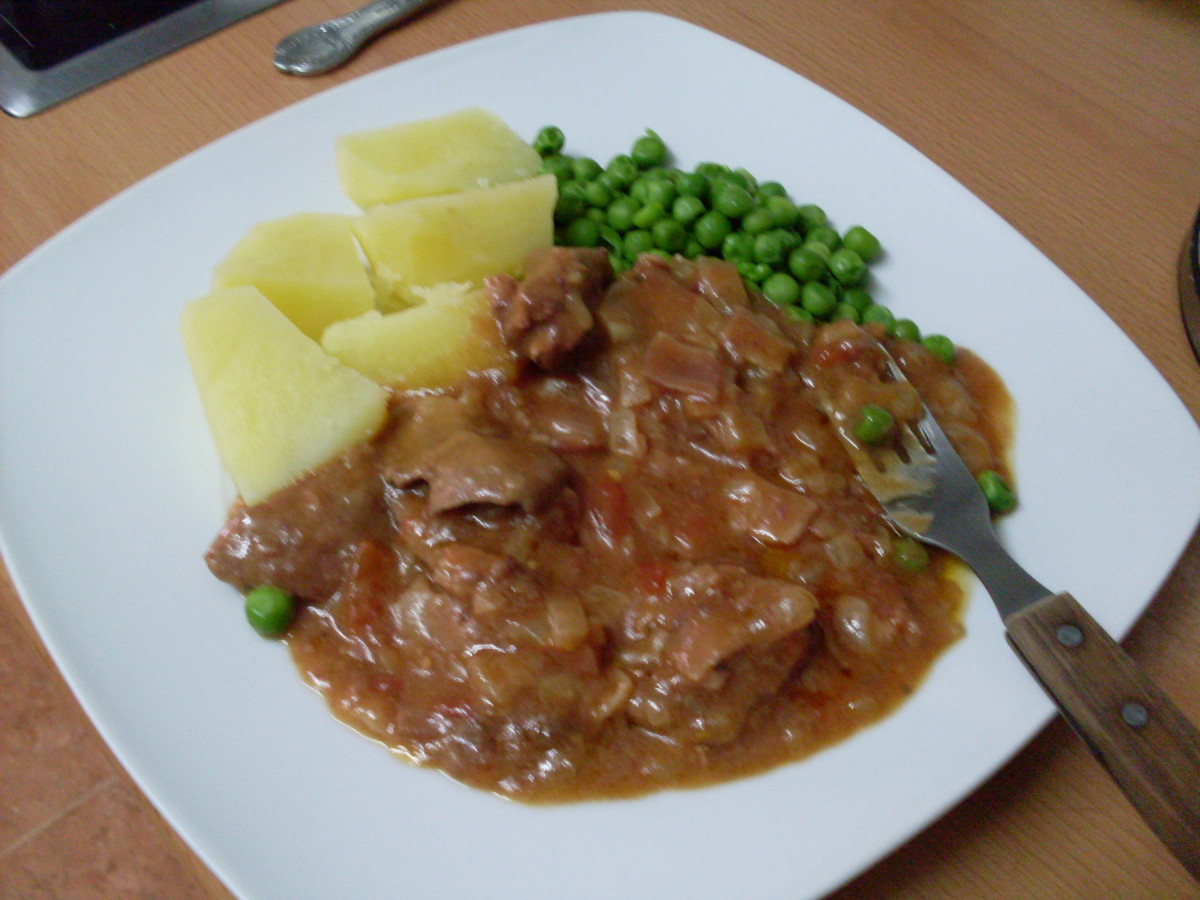 Liver and bacon casserole served with boiled potatoes and peas