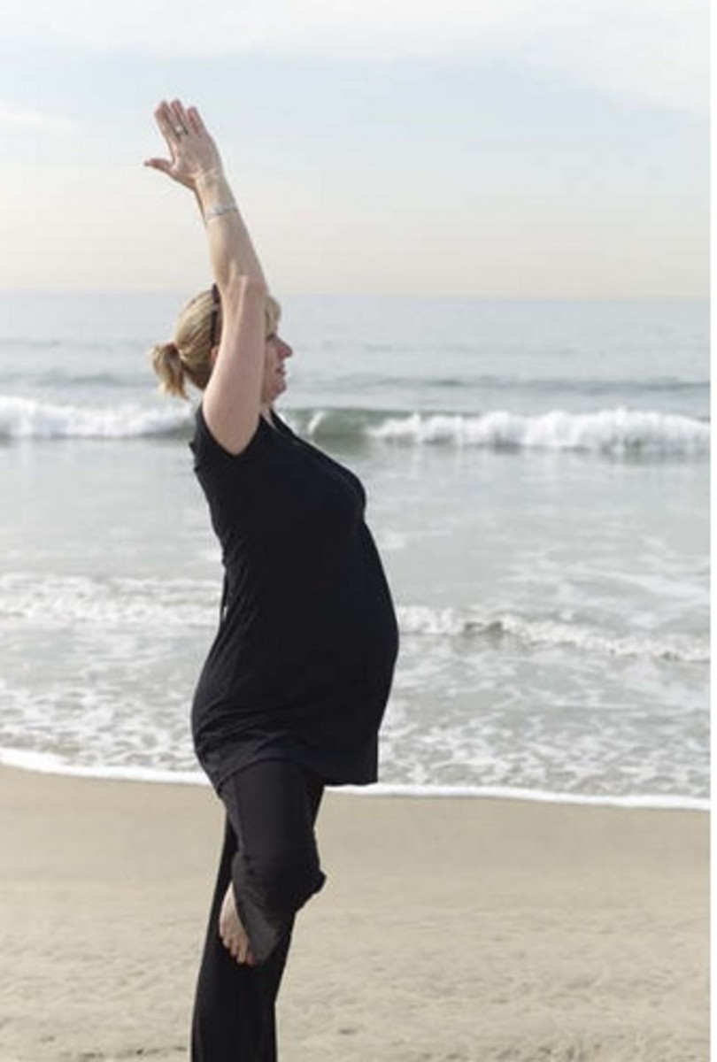 Pregnant Woman at 8 months stands in Tree on the beach.  As the abdomen grows and the body's center of gravity changes, standing balances help connect to the center and find stillness.