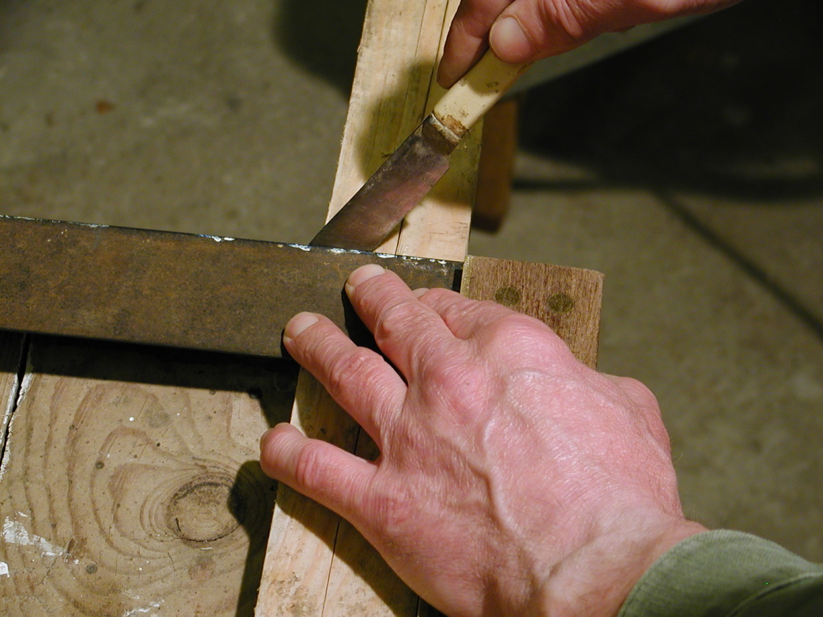 Using a marking knife to mark a section of timber.