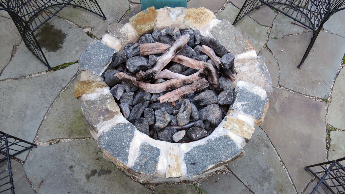 Bird's eye view of gas fire pit completely ready with lava rock and faux logs.