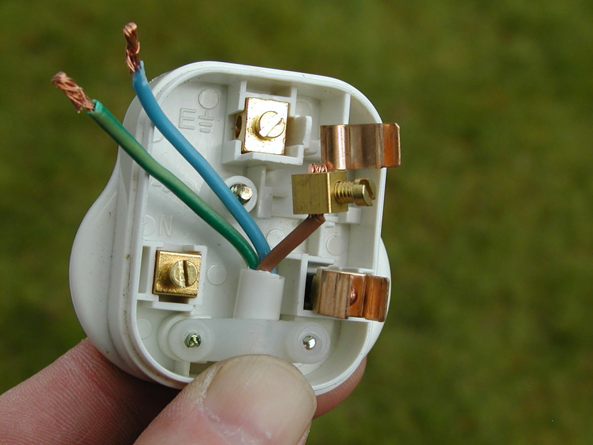 Feed the flex underneath the strain relief and push the strands of the brown wire into the terminal. It is easier to do this if you remove the fuse and terminal from the plug